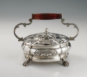silver warmer of circular shape, standing on four paw feet, gadrooned embossed body, pierced lid with floral motif, double scroll handle